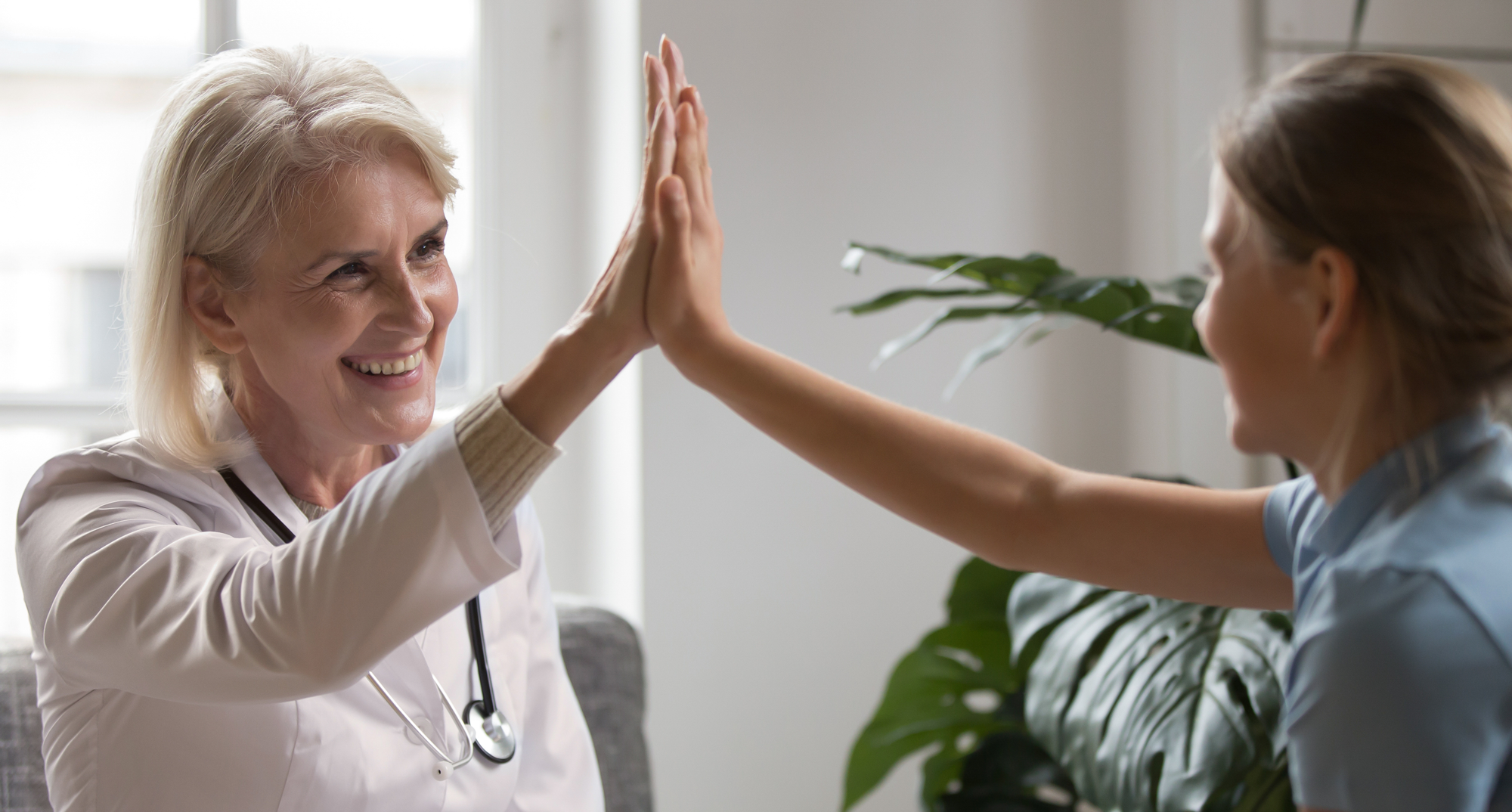 Lege og pasient gjør high-five etter vellykket saksgang